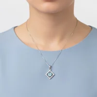 model wearing beautiful square shaped silver pendant with blue topaz and cubic zirconia